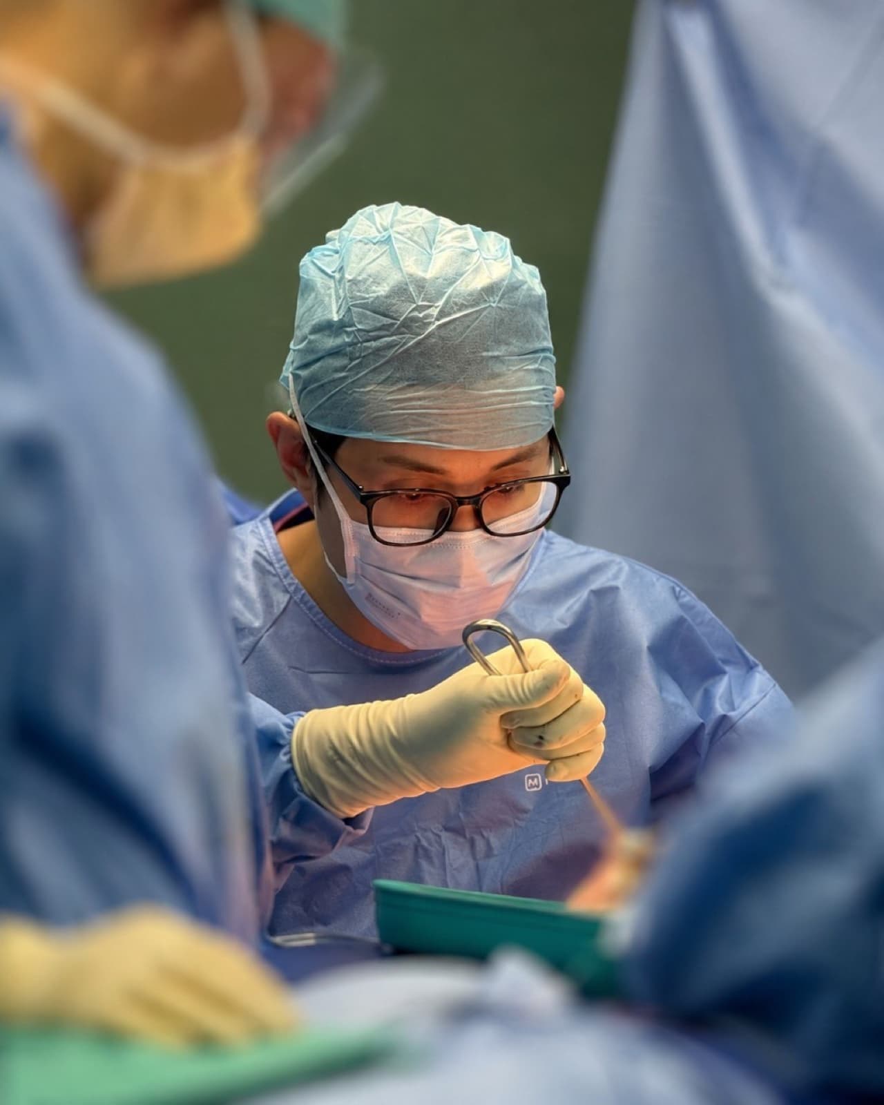 Dr Jeremy Sun operating in a surgical theatre